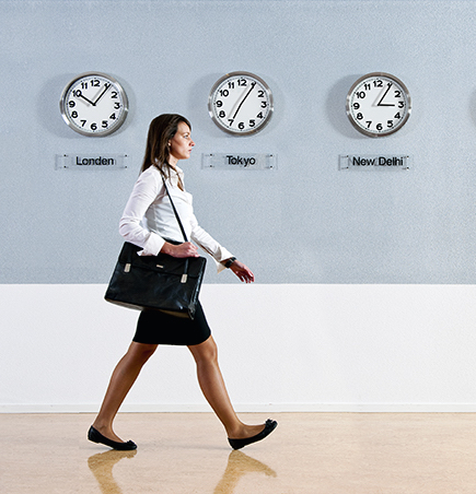Woman walking passed various international clocks