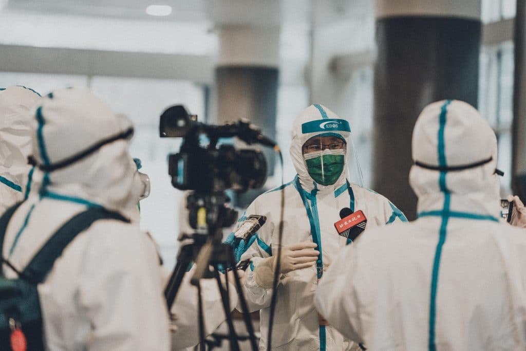 People in PPE being interviewed on camera